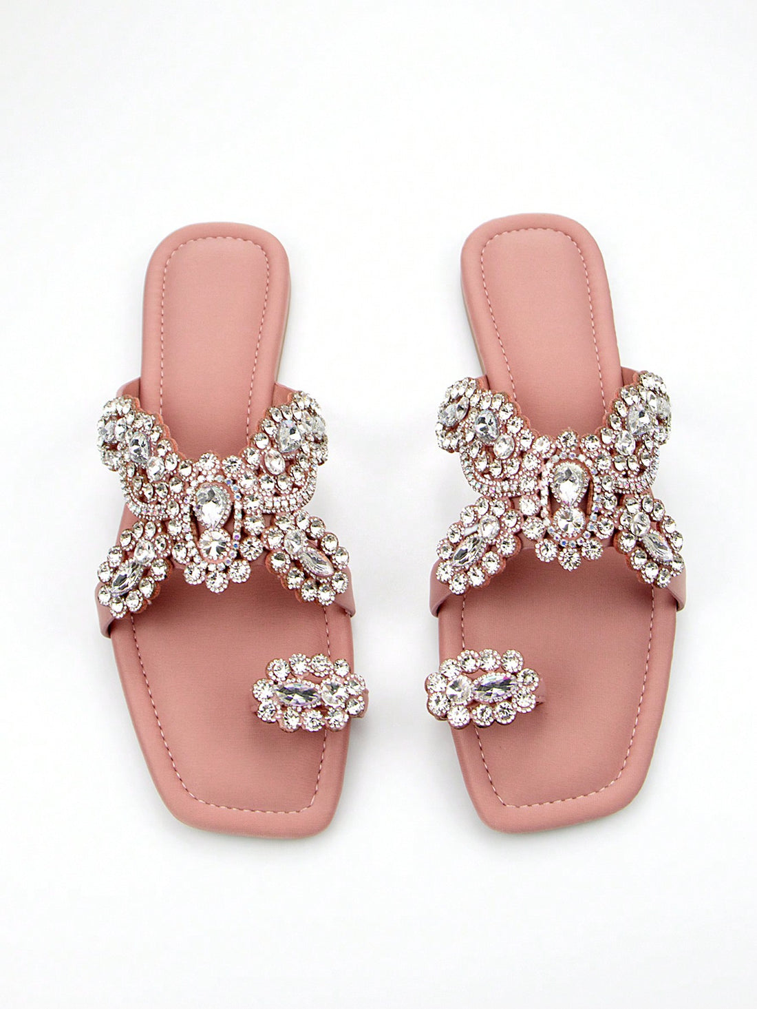 Elevate your party look with our Chic Floral Diamond Slip-On Mules. Featuring a stunning floral design with sparkling diamond accents, these elegant flat sandals are the perfect blend of style and comfort. Step out in style and make a statement at any occasion. Available in pink.