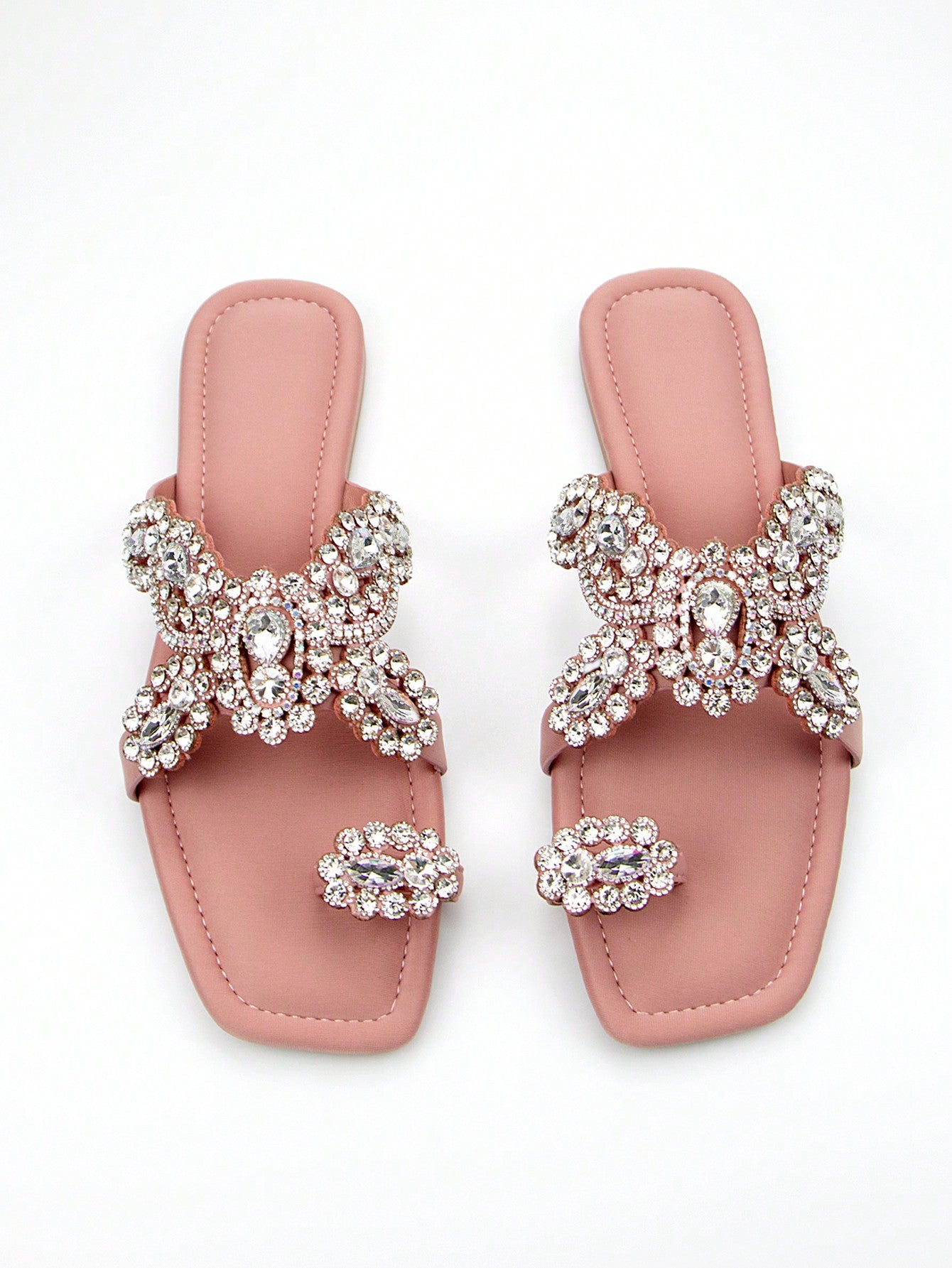 Elevate your party look with our Chic Floral Diamond Slip-On Mules. Featuring a stunning floral design with sparkling diamond accents, these elegant flat sandals are the perfect blend of style and comfort. Step out in style and make a statement at any occasion. Available in pink.