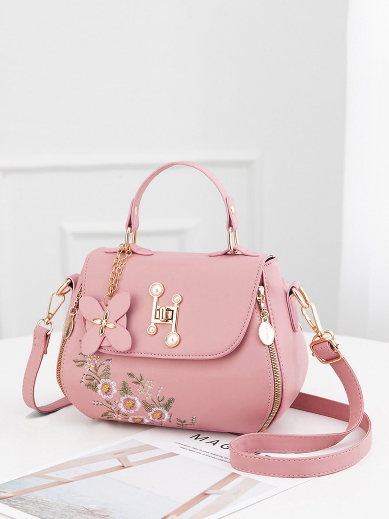Expertly crafted with a chic floral embroidered design and a minimalist silhouette, this crossbody bag is a stylish and functional accessory. Its turn lock design adds a touch of sophistication while keeping your belongings secure. Elevate your everyday look with this must-have handbag.