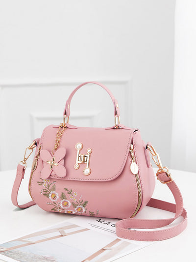 Expertly crafted with a chic floral embroidered design and a minimalist silhouette, this crossbody bag is a stylish and functional accessory. Its turn lock design adds a touch of sophistication while keeping your belongings secure. Elevate your everyday look with this must-have handbag.