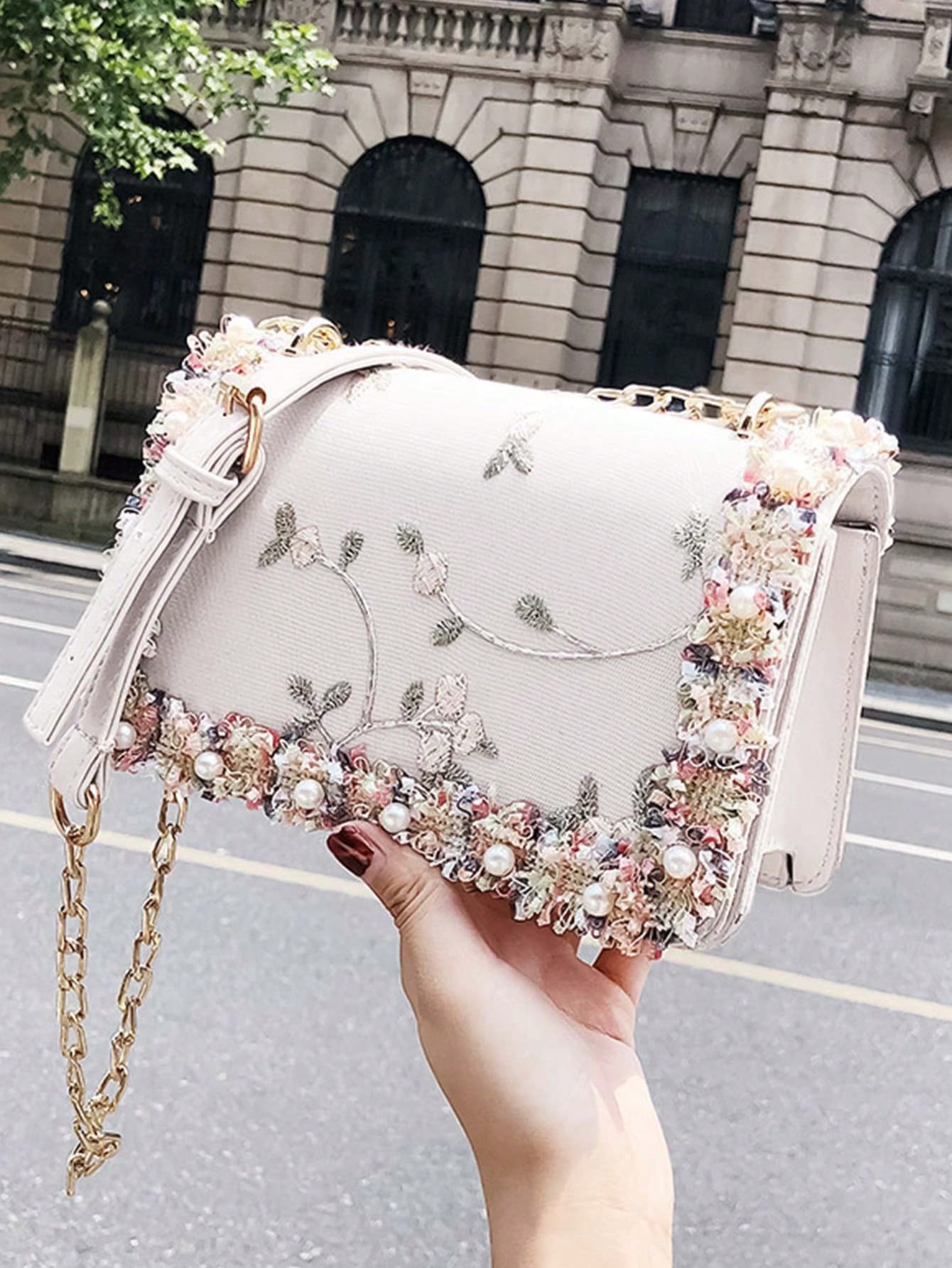 This elegant mini bag features chic floral embroidery and faux pearl accents for a sophisticated look. Perfect for any occasion, this square bag adds a touch of elegance to any outfit. Its compact size makes it a convenient accessory, while its unique design is sure to make a statement.