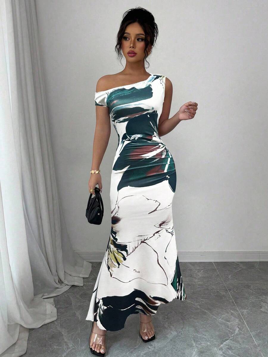 Turn heads at your next celebration in this stunning floral print fishtail dress. The asymmetric neckline adds an unexpected twist of elegance, while the dramatic fishtail hem creates a show-stopping silhouette perfect for summer weddings and holiday gatherings. Vibrant blooms dance across the fabric, bringing fresh, feminine charm to every occasion. Whether you're dancing under the stars or mingling at an outdoor soirée, this dress delivers effortless sophistication with a playful edge. A wardrobe essentia