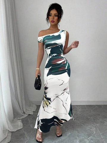 Turn heads at your next celebration in this stunning floral print fishtail dress. The asymmetric neckline adds an unexpected twist of elegance, while the dramatic fishtail hem creates a show-stopping silhouette perfect for summer weddings and holiday gatherings. Vibrant blooms dance across the fabric, bringing fresh, feminine charm to every occasion. Whether you're dancing under the stars or mingling at an outdoor soirée, this dress delivers effortless sophistication with a playful edge. A wardrobe essentia