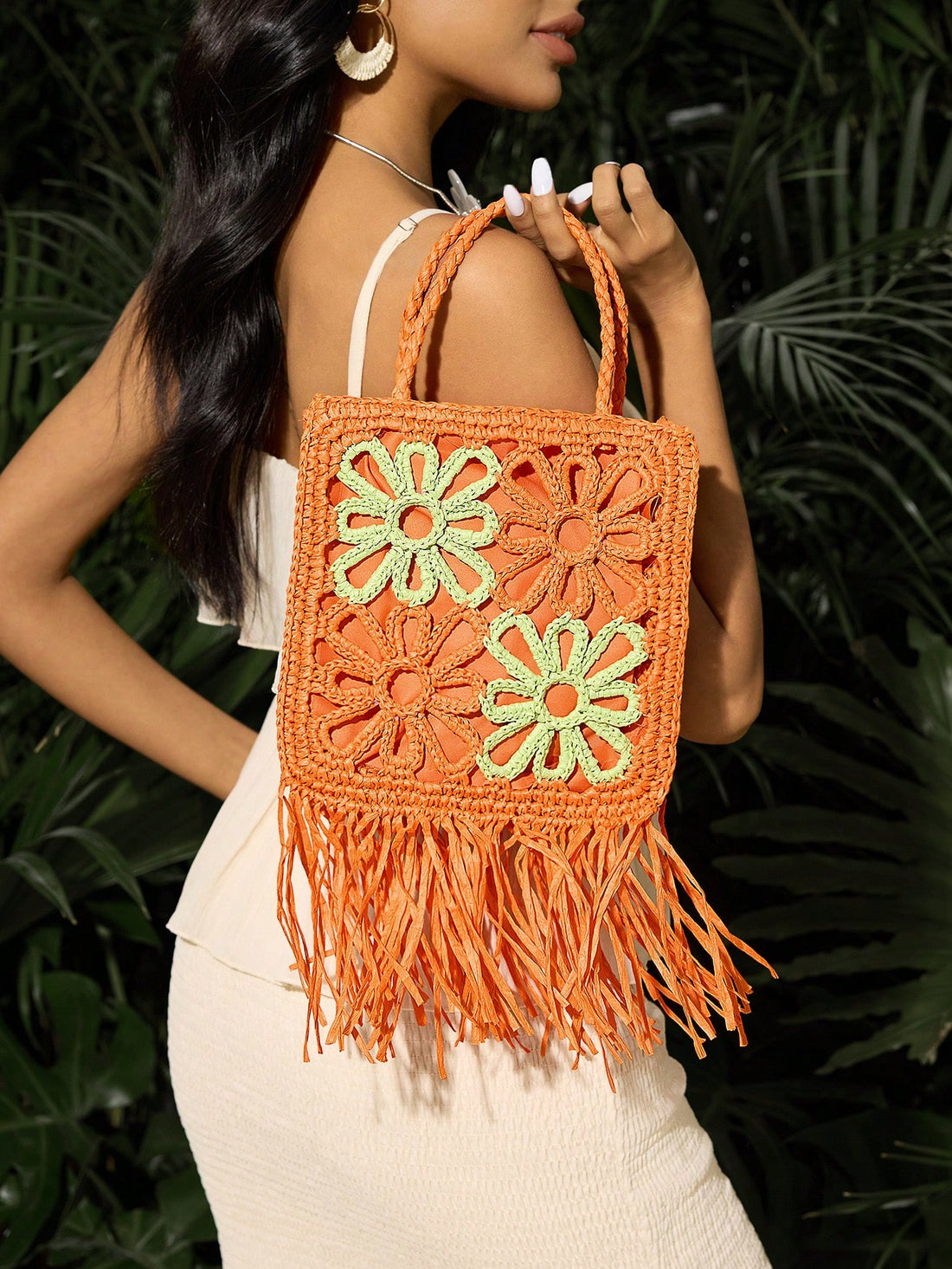 Elevate your beach style with this charming straw bag, perfect for summer getaways. Crafted from lightweight paper straw, it features a vibrant orange colorblock design with delicate floral accents, playful fringe detailing, and decorative tassels. The hollow-out construction adds visual interest while keeping it breathable and practical. Sized just right for essentials, the comfortable double handles make it easy to carry to the shore. An ideal companion for vacations and warm-weather adventures.