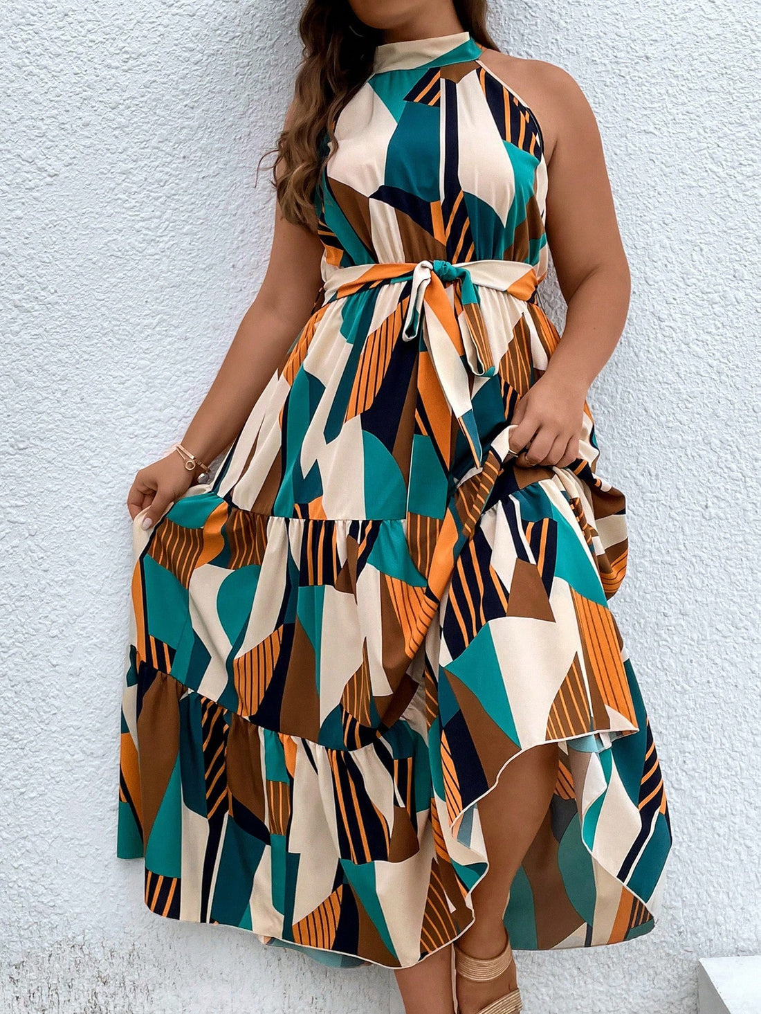 This Chic Geo Print Plus Size Halter Maxi Dress is a must-have for your wardrobe! The bold geo print adds a touch of fun to the classic halter style, while the ruffled hem and belt accentuate your curves. Perfect for any occasion, this dress is both stylish and comfortable.