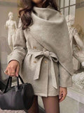 Close front view of grey wrap-collar overcoat with gold-tone double buttons, tied belt and soft textured fabric