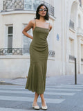Elevate your date night game with this stunning khaki green midi dress that's equal parts sophisticated and flirty. The fitted silhouette hugs your curves in all the right ways, while delicate spaghetti straps keep things effortlessly chic. But here's where it gets interesting—the asymmetric hem adds an unexpected twist that catches the light as you move, giving you that 