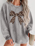 Front worn view of grey oversized crew-neck sweatshirt with leopard-print bow graphic