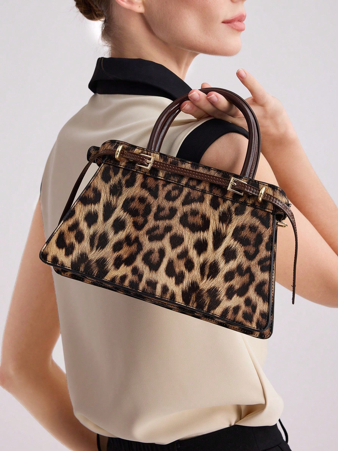 Add a sophisticated touch to your wardrobe with this chic leopard print buckle top handle bag. With its sleek design and trendy pattern, this bag is the perfect accessory to elevate your style. Made from high-quality materials, it's durable and fashionable.