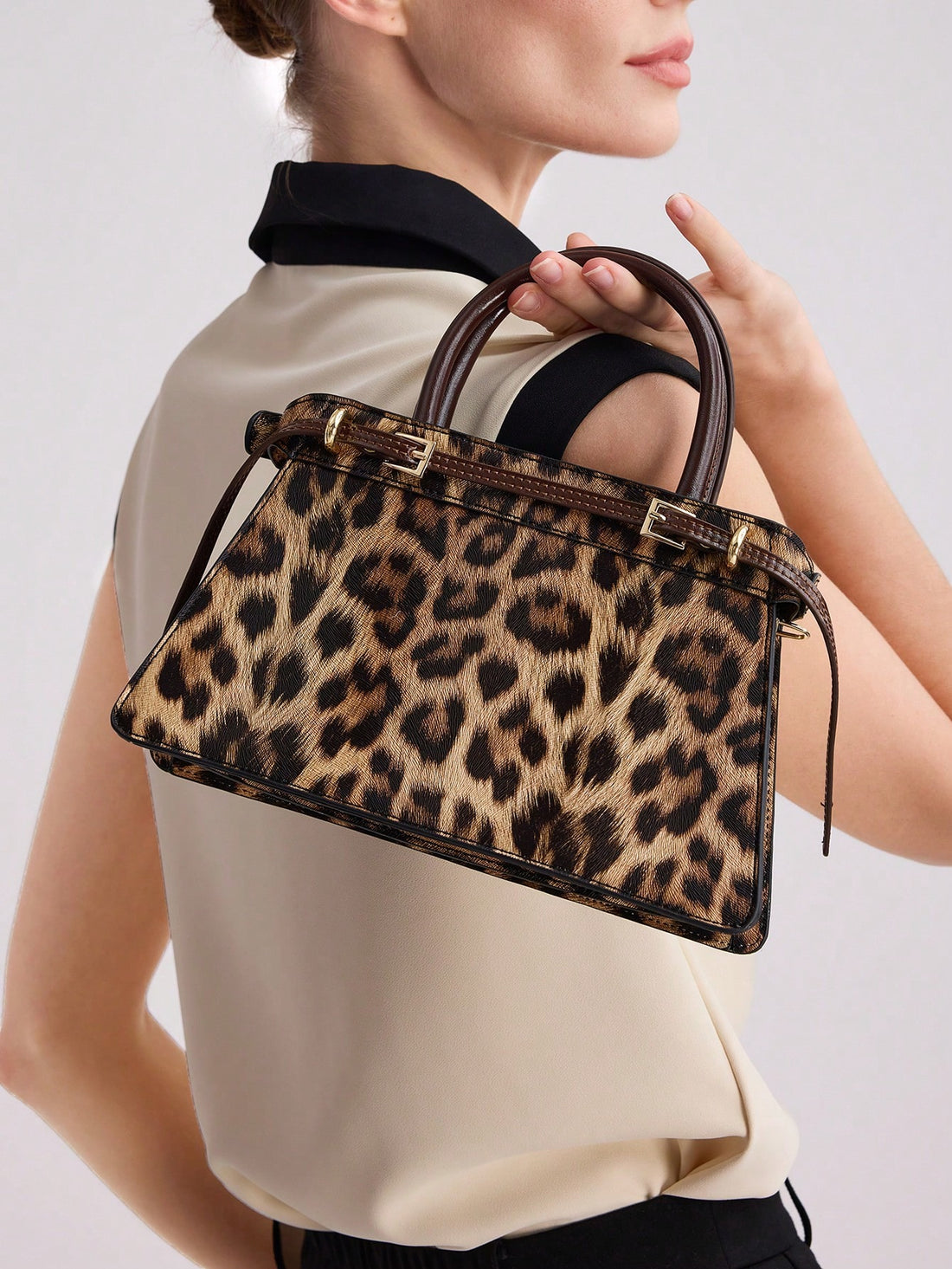 Add a sophisticated touch to your wardrobe with this chic leopard print buckle top handle bag. With its sleek design and trendy pattern, this bag is the perfect accessory to elevate your style. Made from high-quality materials, it's durable and fashionable.