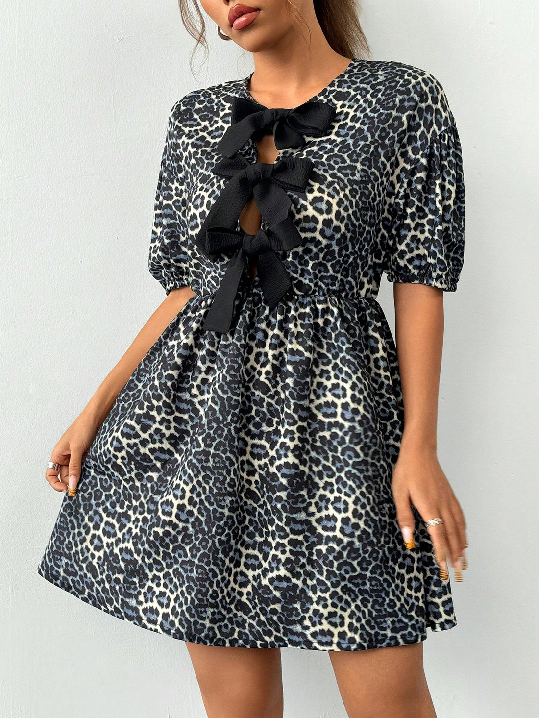 This chic dress features a trendy leopard print and unique half-sleeve design. The bow tie detail adds a touch of femininity, making it the perfect statement piece for any occasion. Elevate your style and feel confident with this dress that combines fashion and functionality.