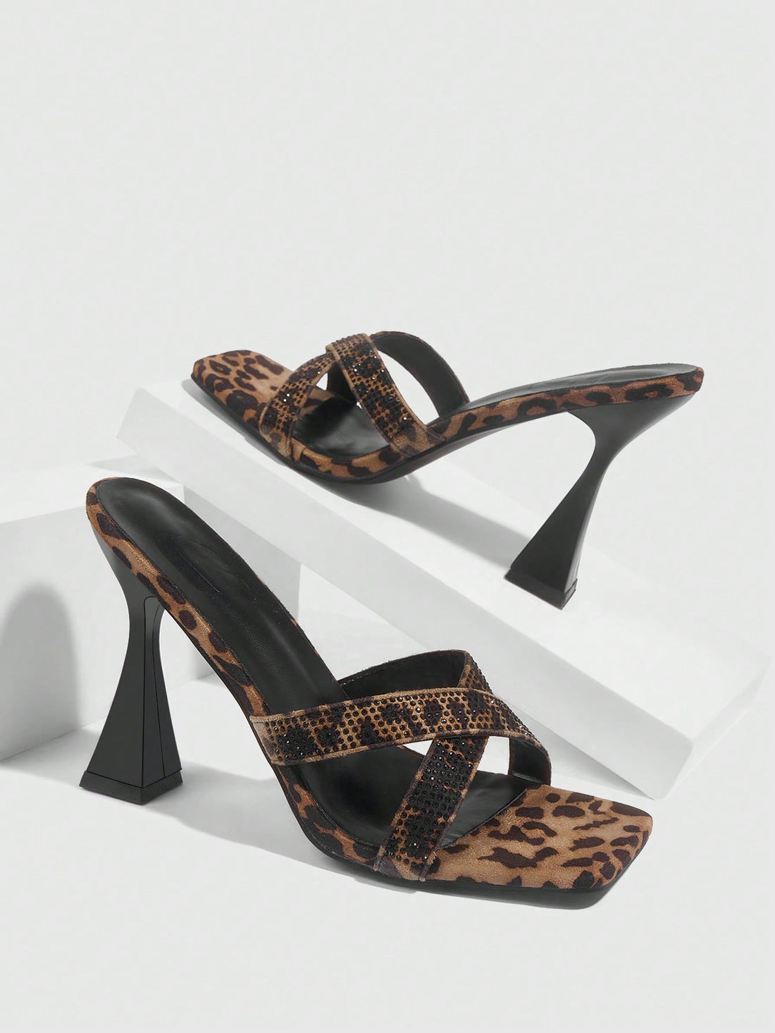 Step out in style with these Chic Leopard Velvet High Heel Mules, featuring a dazzling glitter strap and a trendy square toe design. Perfect for adding a playful touch to any outfit, these sandals combine bold leopard print with sparkling accents to make your look unforgettable. Elevate your wardrobe with comfort and flair in every step.