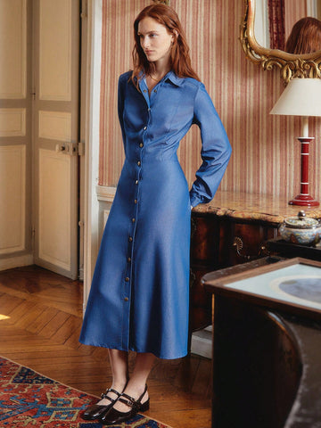Elevate your workweek wardrobe with this stunning maxi shirt dress that effortlessly bridges the gap between polished and playful. Crafted in a rich blue hue, it features eye-catching gold buttons that add a touch of sophistication to every outfit. The relaxed silhouette drapes beautifully, making it perfect for layering through autumn and winter months. Slip it on over a tee, pair with your favorite boots, or dress it up for the office—this versatile piece does it all. Say goodbye to outfit indecision and 