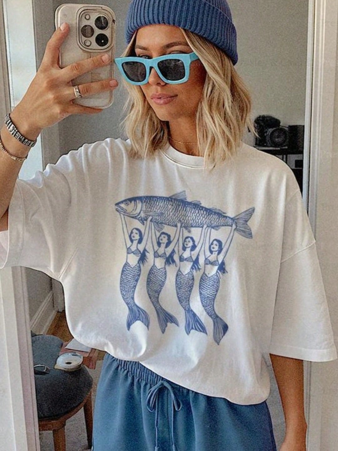 Dive into effortless style with the Chic Mermaid Sardine Graphic Tee, perfect for those who love a splash of whimsy and the La Dolce Vita vibe. This playful tee pairs a quirky sardine mermaid design with a trendy aesthetic, making it a fun statement piece for casual days or lively outings. Embrace your unique style and let this tee add a touch of charm and personality to your wardrobe.