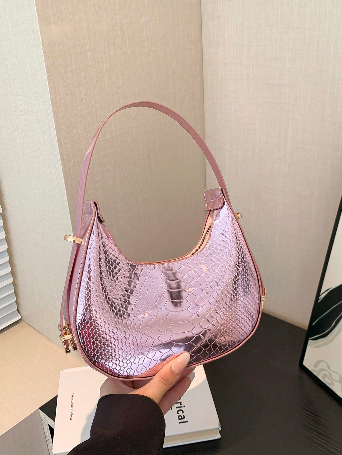 Introducing our Chic Metallic Snakeskin Hobo Bag, a trendy accessory that effortlessly elevates your style. The crocodile embossed design adds a touch of luxury while the spacious hobo style offers practicality. With its metallic sheen, this bag is perfect for any occasion. Experience effortless style now.