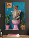 Unframed leopard canvas wall art showing spotted leopard reading a newspaper on a pink toilet with teal wall and plants