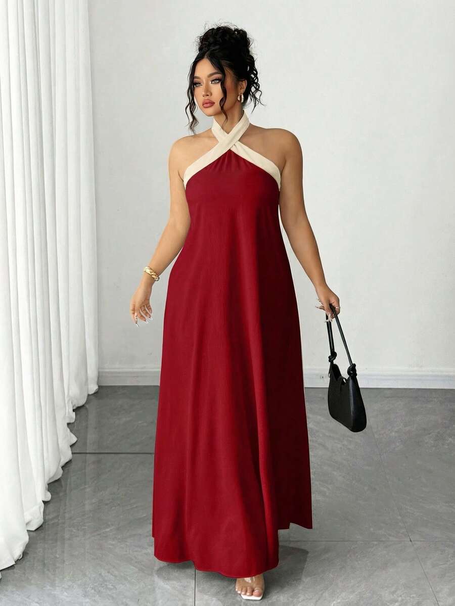 Elevate your wardrobe with this stunning plus-size halter neck maxi dress in rich burgundy. Featuring a flattering A-line silhouette with a backless design and criss-cross detailing, this versatile piece transitions seamlessly from casual outings to formal events. The split sleeves and contrast binding add contemporary flair, while the natural waistline creates a refined, elongated look. Crafted from a woven polyester-elastane blend, this dress offers comfortable everyday wear with sophisticated style. Perf