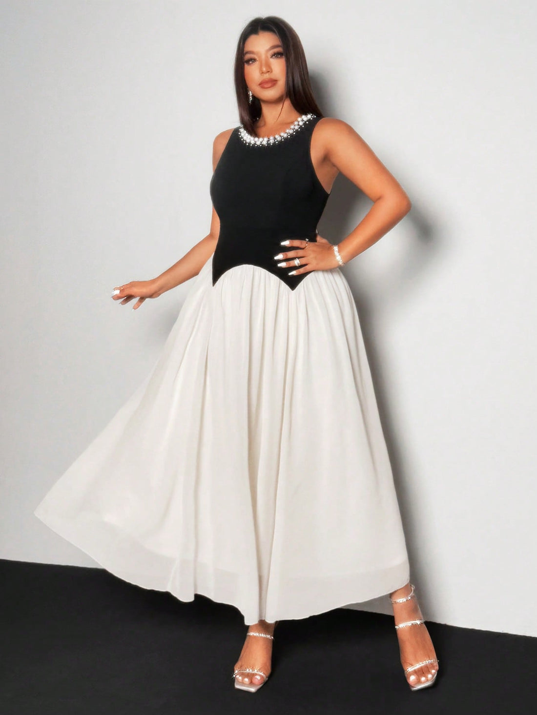 Step into effortless elegance with this chic plus size chiffon dress featuring a striking pearl and black color block design. Its flowing fabric moves gracefully, making every moment feel special. Perfect for turning heads with a playful touch of sophistication.