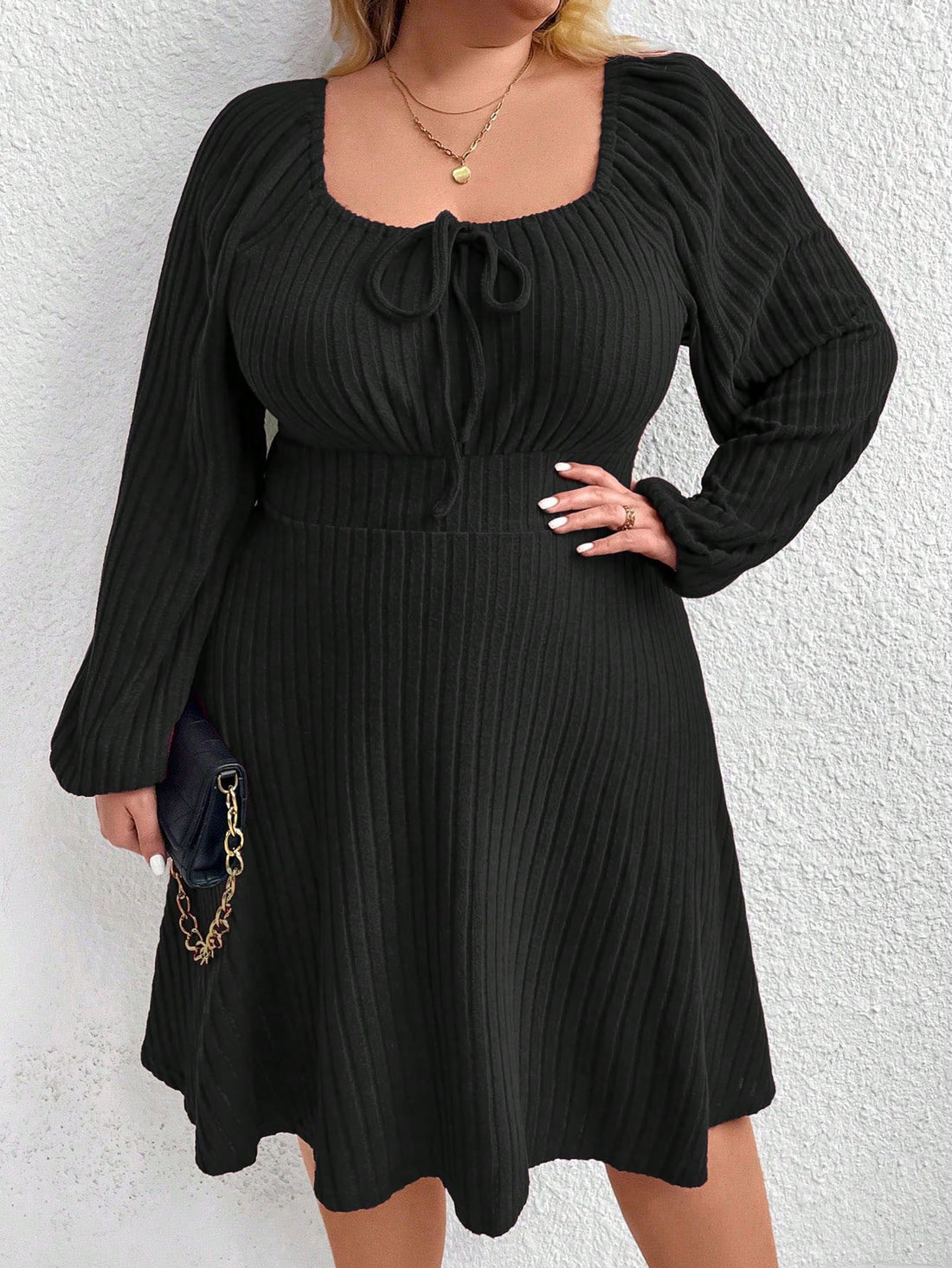 This effortlessly stylish plus size dress features a ribbed texture, a knotted front, and lantern sleeves. Perfect for any occasion, it's chic, comfy, and easy to wear. You'll look good and feel good in this dress, making it a must-have for your wardrobe.