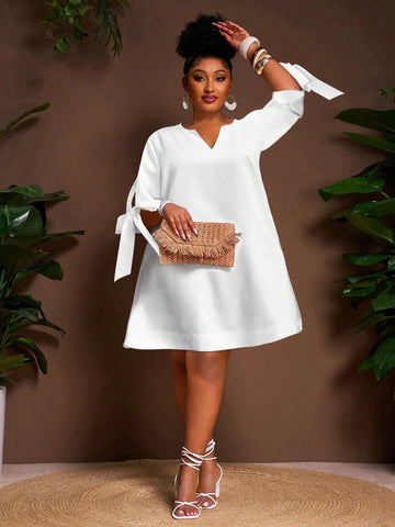 This playful plus size white mini dress features a flattering V-neck and a charming tie front, perfect for sunny summer vacations. Its breezy A-line silhouette keeps you comfortable and effortlessly chic, whether you’re exploring a new city or lounging by the beach. Add a splash of fun to your warm-weather wardrobe with this versatile and stylish summer essential.