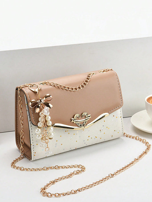 This small shoulder bag features a chic two-tone design with faux pearl accents, adding a touch of sophistication to any outfit. The compact size is perfect for keeping your essentials within reach while on-the-go. Add a classy touch to your wardrobe with this elegant bag.