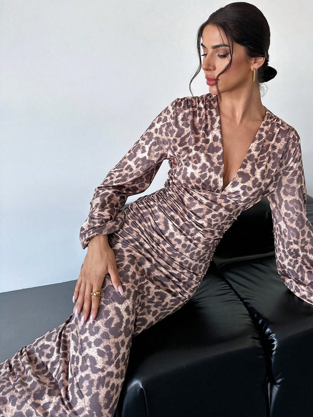 This elegant dress is perfect for fall events. Its chic V-neckline and leopard print make a stylish statement, while the ruched puff sleeves add a touch of sophistication. Make a lasting impression with this must-have dress.