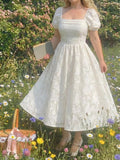 Chic white summer party dress with a square neckline and puffed petal sleeves. Perfect for brunches, garden parties, vacations, and special events.