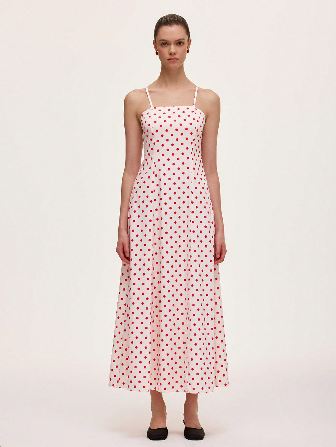 This playful polka dot cami midi dress is designed to flatter your figure with a waist-cinching silhouette that adds a touch of charm to your look. Its breezy midi length and delicate straps make it perfect for effortless style, whether you're out for brunch or dancing the night away. Embrace fun and feminine vibes with this chic wardrobe staple.