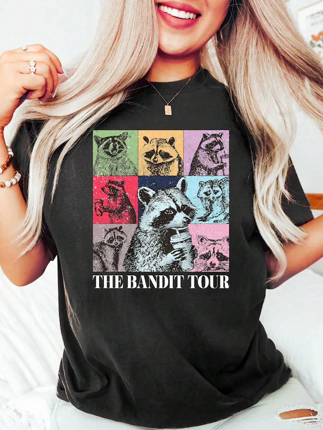 This Coffee-Loving Raccoon Graphic Tee features a fun and quirky design, perfect for any coffee-loving woman. Made from comfortable fabric, this t-shirt is a must-have for any casual outfit. Show off your love for coffee and your unique style with this graphic tee.