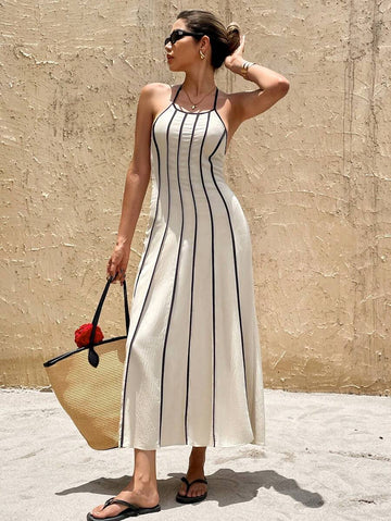Front view of ivory halter maxi dress with black vertical piping