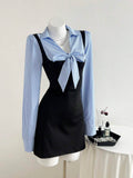 Three-quarter front view of black and blue striped bow waist long sleeve mini dress