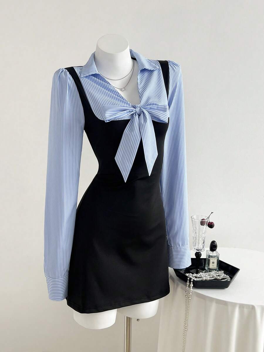 Three-quarter front view of black and blue striped bow waist long sleeve mini dress
