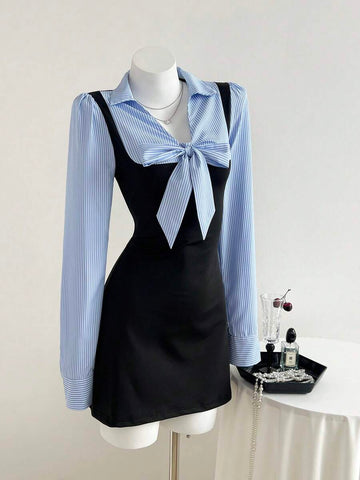 Three-quarter front view of black and blue striped bow waist long sleeve mini dress