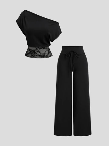 Full view of black two-piece pants set with batwing-sleeve lace-hem top and knotted waistband