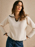 Front view of apricot knit pullover with black scalloped trim styled with blue jeans