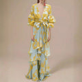 Full front view of pale blue and mustard tropical print belted maxi dress with tiered ruffles