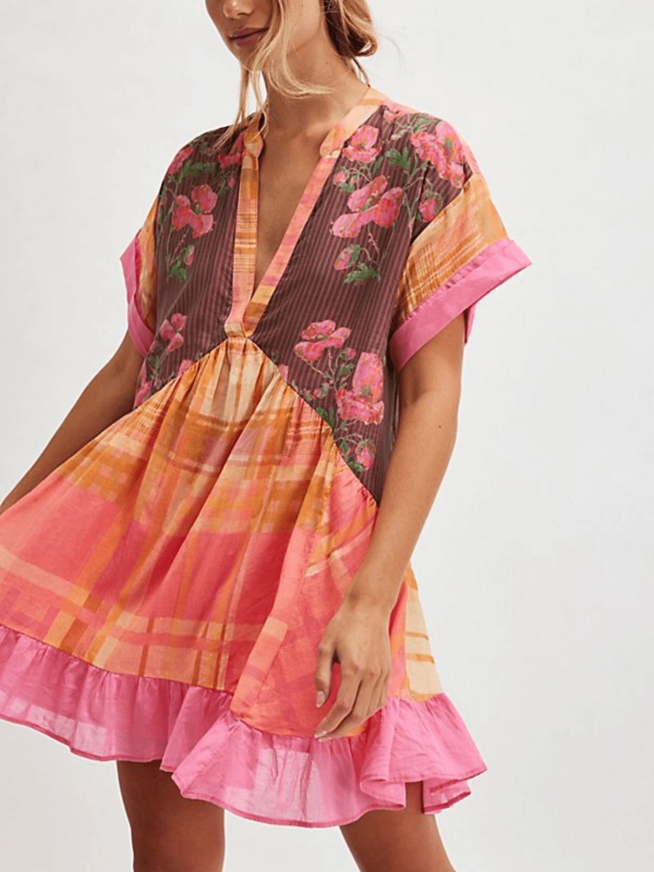 Front three-quarter view of pink floral plaid babydoll mini dress with gathered skirt