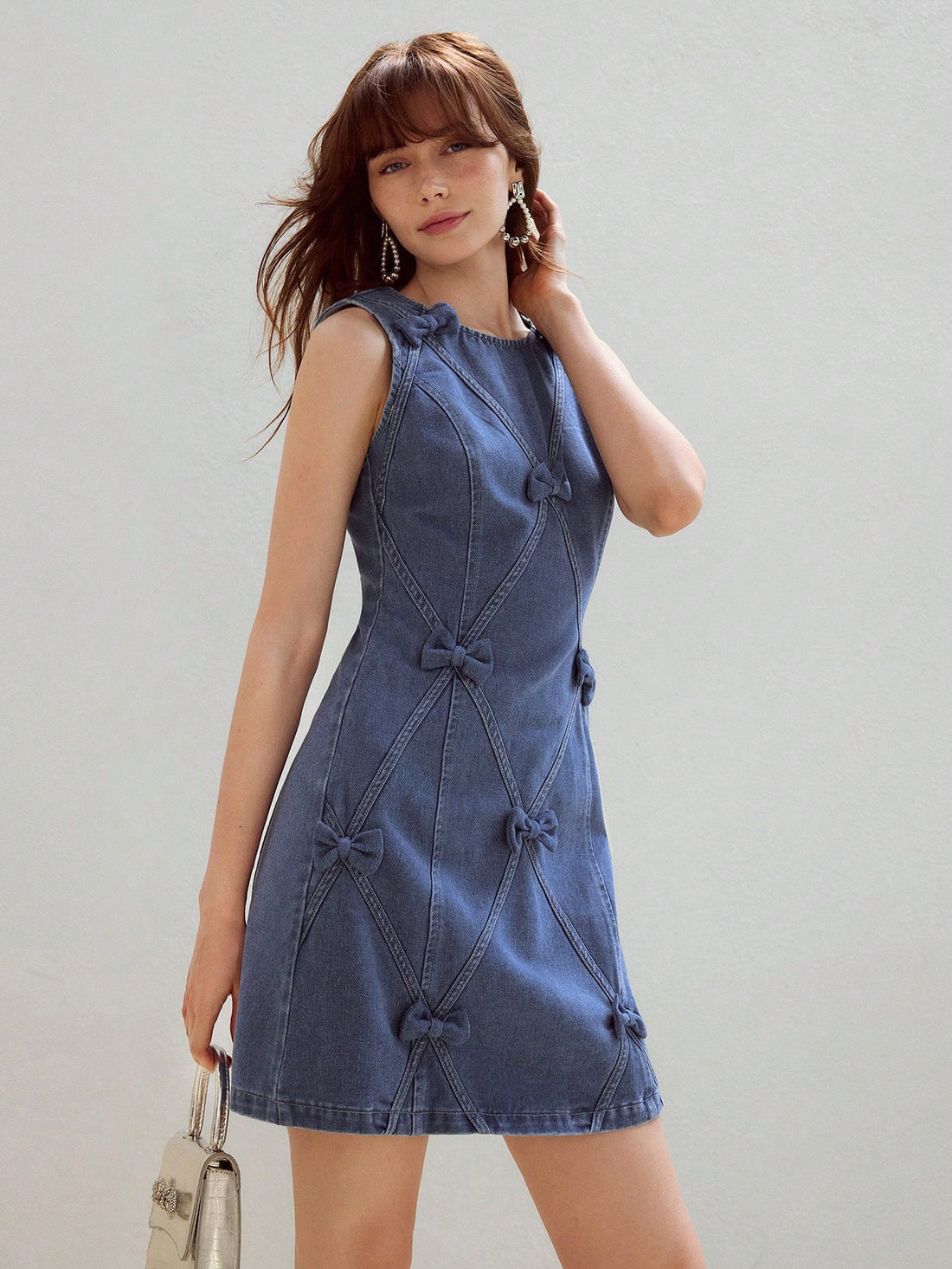 Step out in style with this playful denim dress featuring a charming bow detail and a convenient zipper back. Its chic tank silhouette offers a flattering fit that's perfect for sunny days or casual outings. Easy to wear and effortlessly cute, this dress adds a fun twist to your wardrobe essentials.