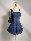 Full front view of square-neck denim mini dress with fitted bodice and pleated skirt