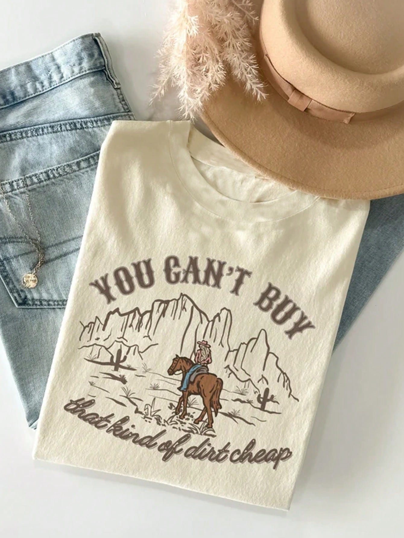 Get your cowgirl groove on with our Desert Dreamin' Graphic Tee! Perfect for country music lovers, this stylish western-inspired t-shirt adds a touch of fun to any outfit. Dream of the desert and rock this tee with confidence. Yee-haw!