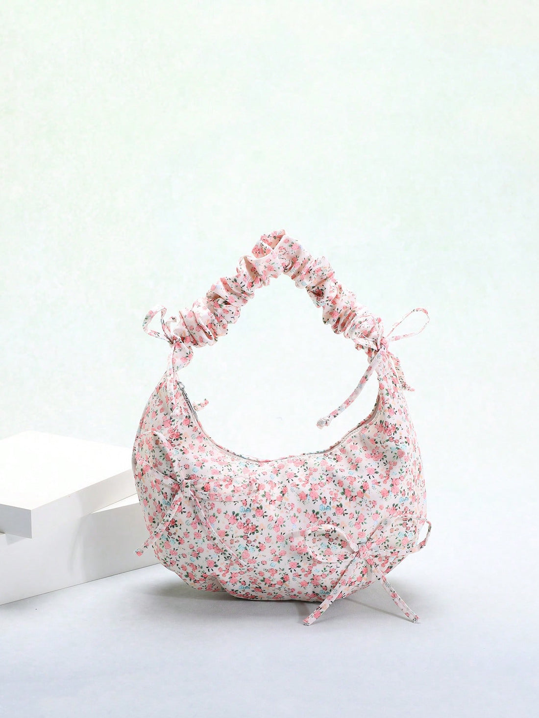 Expertly crafted for both style and convenience, our Ditsy Floral Dumpling Handbag is the perfect addition to any fashion-forward wardrobe. Made in the popular Korean fashion style, this shoulder bag features a beautiful bowknot decoration that adds a touch of elegance to your everyday look. Practical and chic, this handbag is a must-have accessory for any fashion lover.
