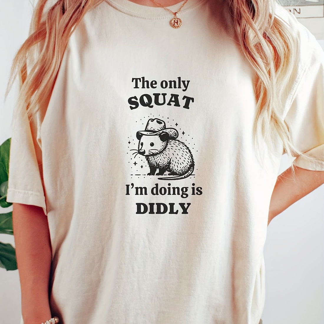 This Doodly Squat Print T-Shirt for Women features a unique design and a comfortable fit. The crew neck and short sleeves make it perfect for casual wear. Made with high-quality fabric, it offers both style and comfort. Show off your personality with this one-of-a-kind t-shirt.