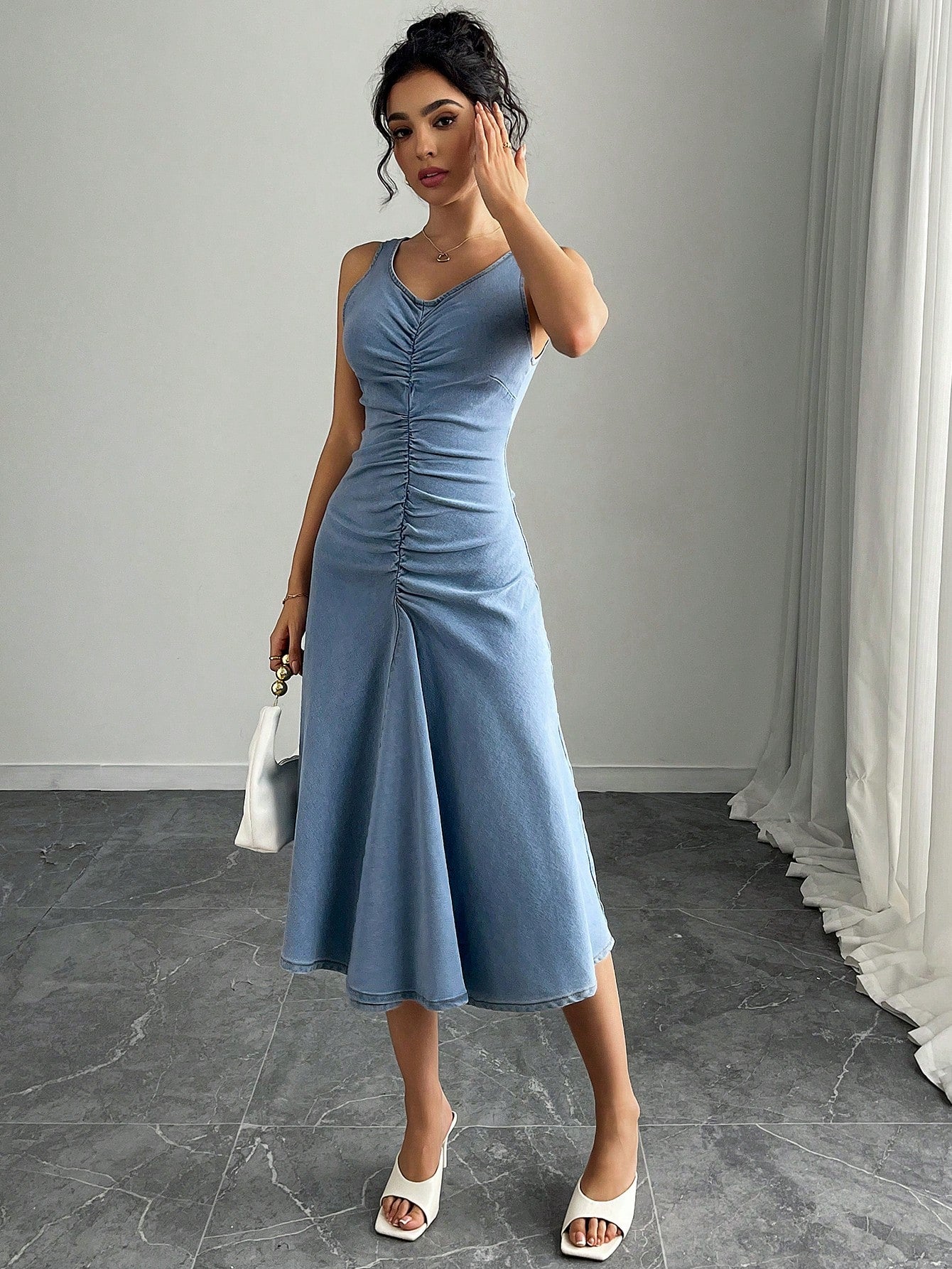 Effortlessly chic, this V-neck sleeveless denim maxi dress is the perfect addition to any woman's wardrobe. With its gathered design and flattering fit, it's the ideal choice for a stylish and comfortable look. Dress it up or down, this versatile piece will make you feel effortlessly stylish.