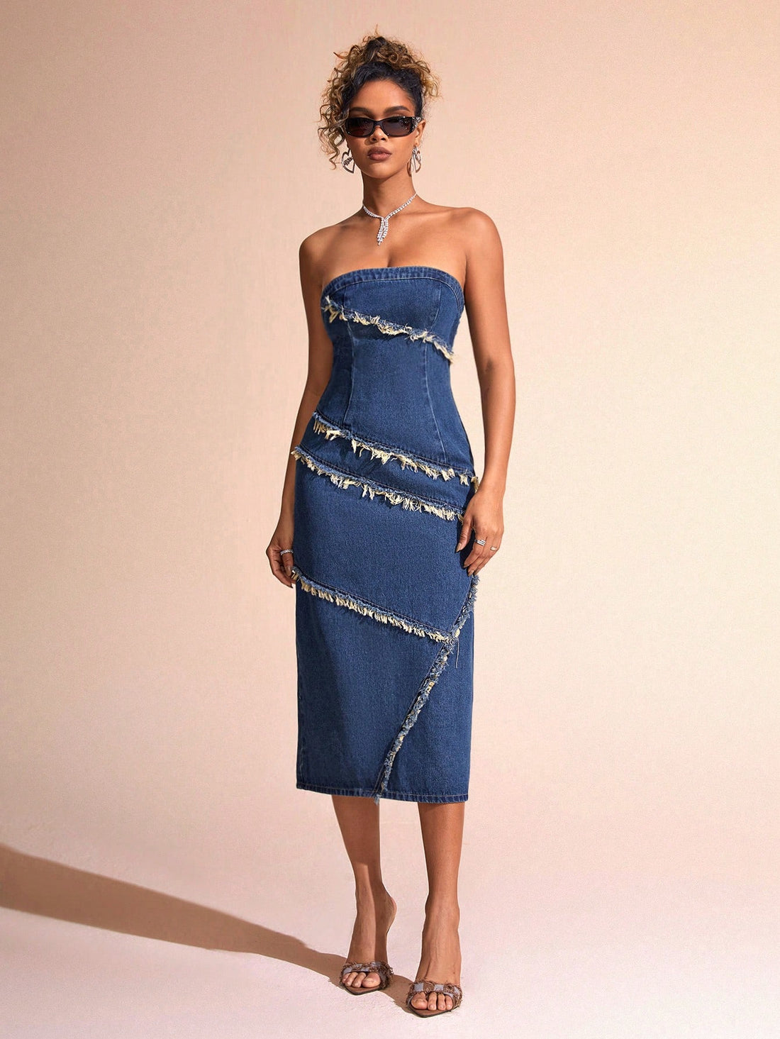 Effortlessly chic meets trendy in this strapless denim dress with frayed trim. Perfect for any occasion, this dress will keep you cool while looking stylish. Say goodbye to boring dresses and hello to effortless fashion with this must-have piece.