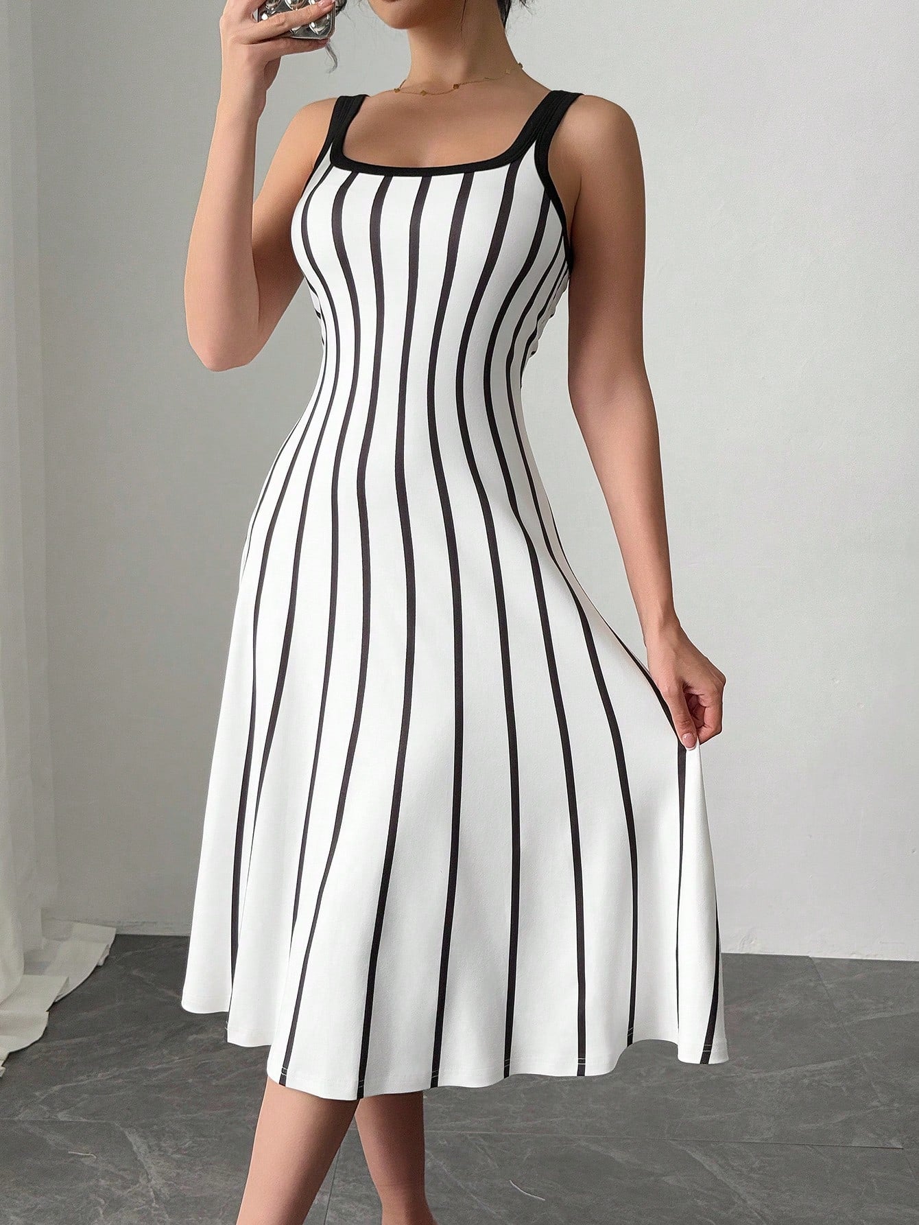 Get ready to turn heads with this effortlessly chic black and white striped dress! The loose-fit design and wide straps make it comfortable to wear all day long, while still looking stylish. Perfect for any occasion, this dress is a must-have for your wardrobe.