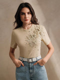 Elevate your everyday style with this stunning women's t-shirt featuring intricate 3D floral appliqués that add dimension and visual interest. The classic round neckline and comfortable short sleeves make it perfect for casual outings, while the delicate floral details bring a touch of botanical elegance to your wardrobe. Whether you're dressing up for brunch or keeping it relaxed, this versatile piece effortlessly transitions from day to night. Crafted for comfort and designed to turn heads, it's the perfe