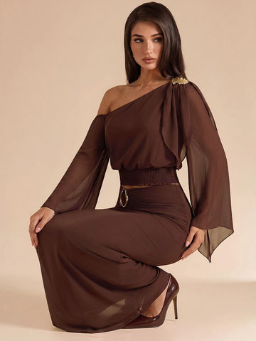 Front view of brown asymmetrical crop top and maxi skirt set with gold waist detail