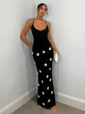 Black fitted maxi dress with thin straps and white floral appliques
