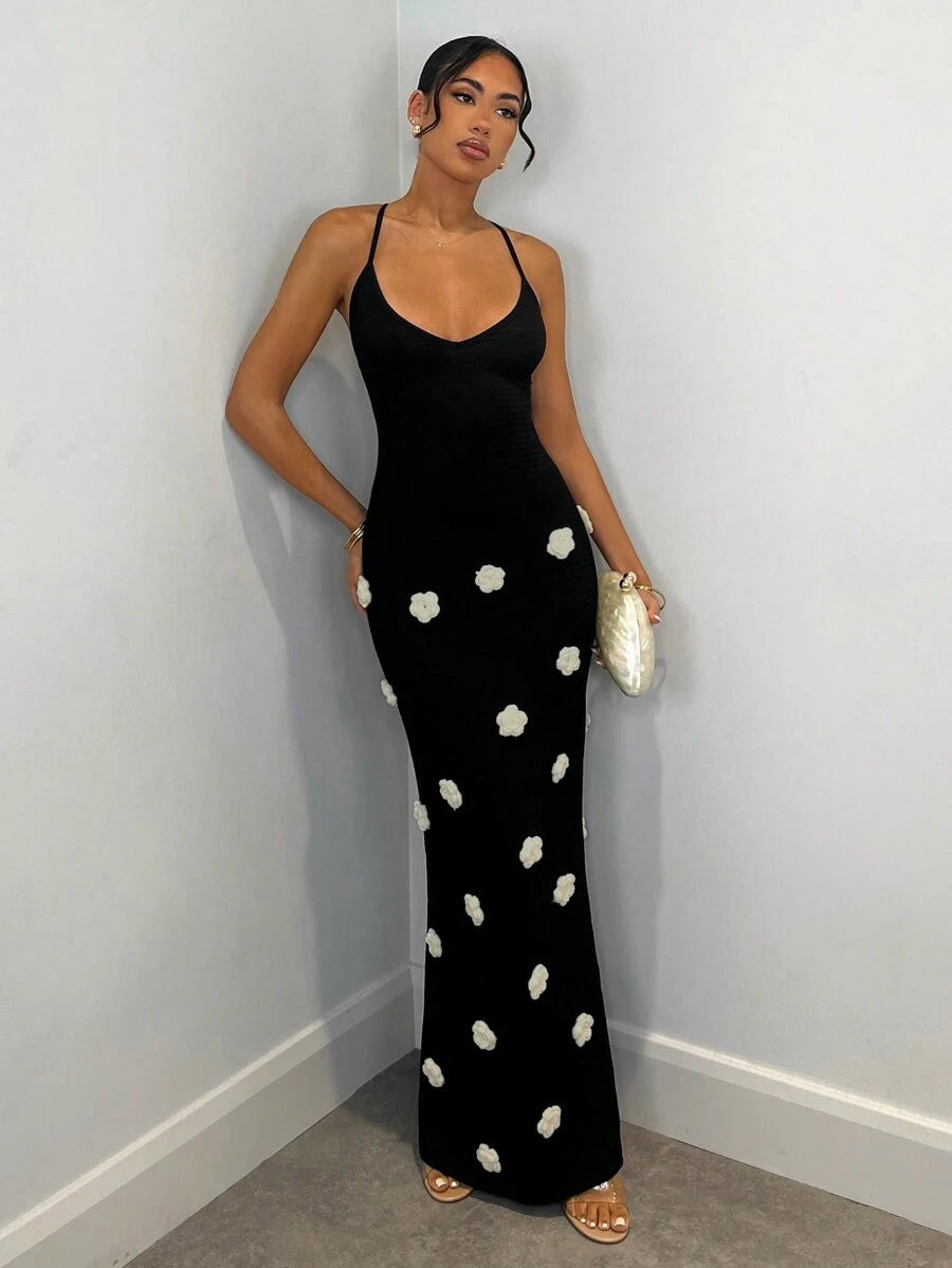 Black fitted maxi dress with thin straps and white floral appliques