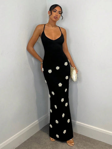 Black fitted maxi dress with thin straps and white floral appliques
